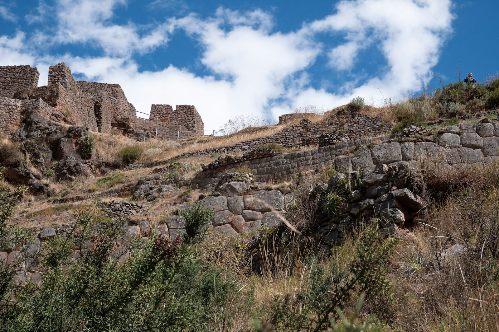 a stone wall on a hill with a sky background